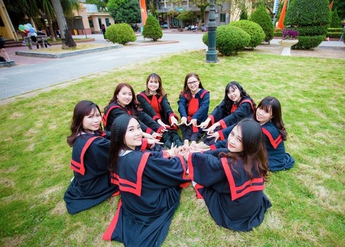 Tạo dáng chụp ảnh với áo cử nhân và thiên nhiên hoa cỏ